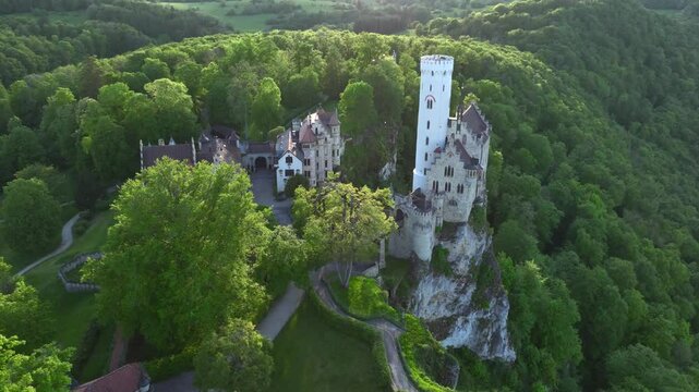 Aerial view on Lichtenstein Castle in Germany at Summer evening. White Tower of the castle with the village in the back.