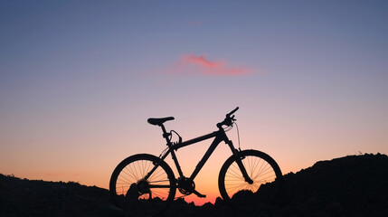 Fototapeta premium The silhouette of a bike on the sunset sky background