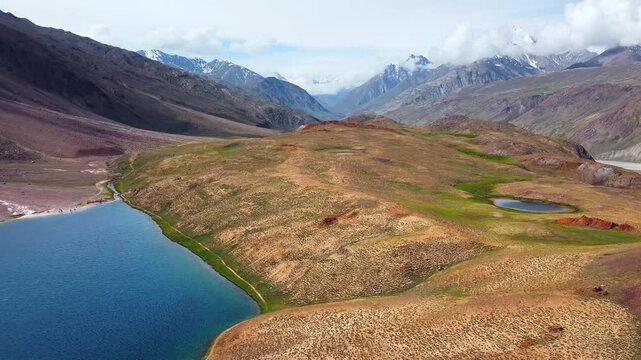 Aerial view of chandratal lake surrounded by snow-capped Himalayan mountains at chandratal in lahaul and spiti valley himachal pradesh, India.