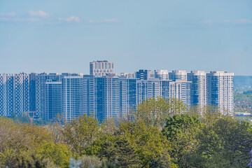Image of a modern apartment complex with green surroundings, clear sky, and no people or vehicles...