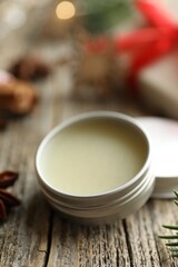 Natural solid perfume in container on wooden table, closeup