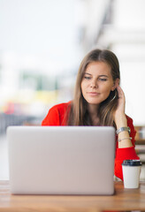 Young businesswoman on a coffee break. Using tablet computer.