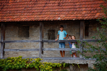 Children enjoy the view from an old stone building's balcony