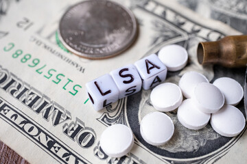 dollars in close-up bullet casings coins and writing cubes with ''LSA''
