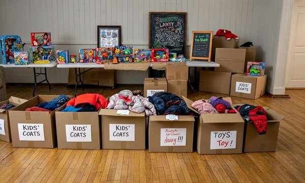 Room organized with boxes labeled for kids' coats and toys, showcasing donation drive
