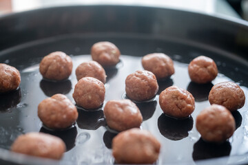 Round Swedish meatballs on a black tray	