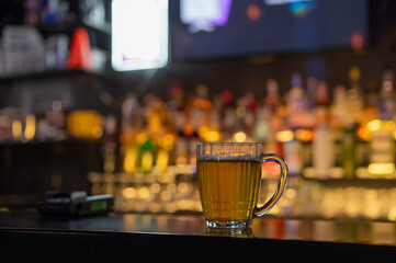 A mug of beer on the bar counter in a pub.
