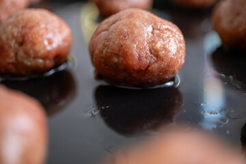 Round Swedish meatballs on a black tray	