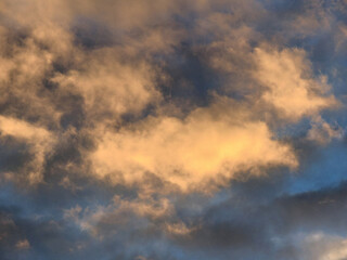 interesting golden clouds in front of blue sky in the evening suitable as background or wallpaper with lots of copy space

