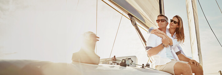 Travel, sailing and couple on boat at sunset for cruise on holiday, vacation and journey. Happy,...