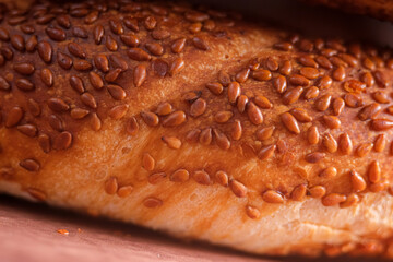 Close-up of a traditional Turkish bread, covered in toasted sesame seeds. A macro shot highlighting the texture and details of a freshly baked simit.