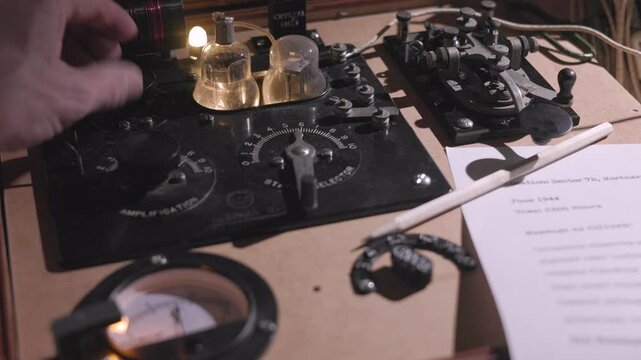 WWII spy turning on and tuning his transmitter