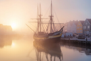 Naklejka premium Old ship docked in a harbor at sunrise, soft mist, gentle tones, peaceful and historical atmosphere 