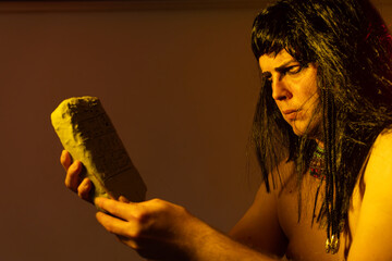 
An ancient Egyptian man holds an Egyptian antiquity cuneiform clay tablet in his hands with...