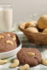 Tasty chocolate cookies with cashew on table, closeup