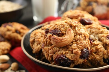 Delicious oatmeal cookies with raisins and nuts on table, closeup