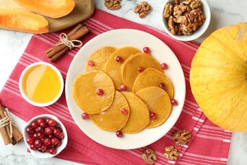 Tasty pumpkin pancakes served on white marble table, flat lay