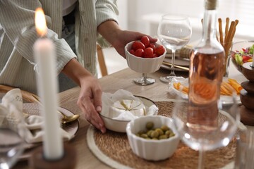 Woman setting table for dinner at home, closeup