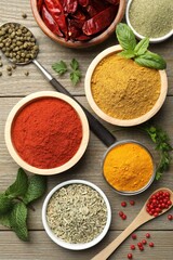 Different aromatic spices on wooden table, flat lay