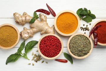 Different aromatic spices on white wooden table, flat lay