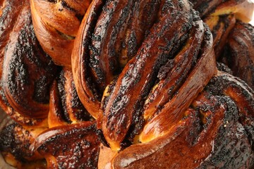 Tasty buns with poppy seeds as background, top view