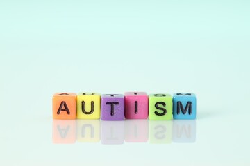 Word Autism made of colorful cubes on light background