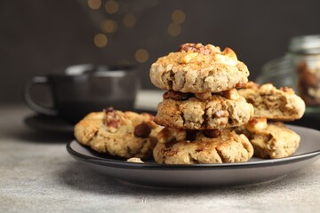 Tasty cookies with nuts on gray textured table, closeup