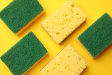 Soft sponges on yellow background, flat lay. Cleaning tool