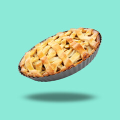 Delicious traditional apple pie in air on turquoise background