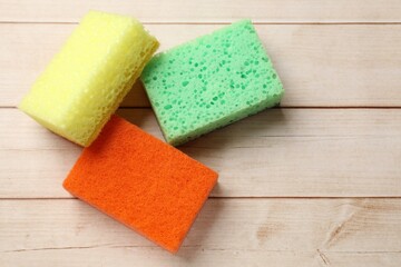 Soft sponges on wooden table, top view. Space for text