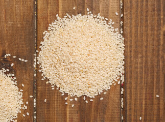 scattered sesame seeds on wooden background