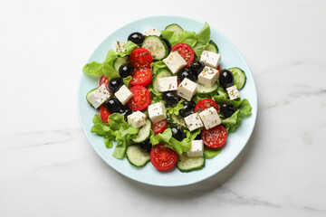 Delicious salad with feta cheese on white marble table, top view