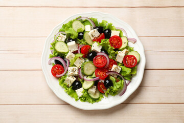 Delicious salad with feta cheese on wooden table, top view