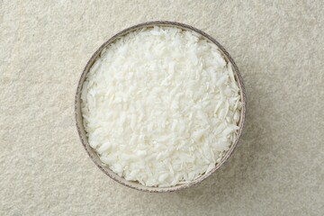 Soy wax in bowl on white textured table, top view