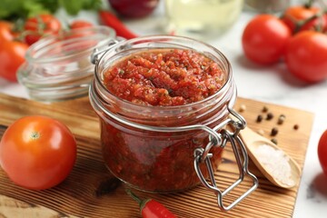 Spicy salsa and ingredients on table, closeup