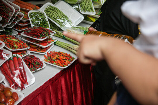 Buyers choose vegetables at a bazaar.