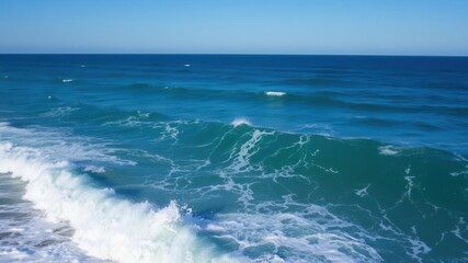 Fototapeta premium Powerful ocean wave crashing on the shore under a clear blue sky, shore, clear sky