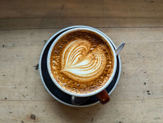 Top view of a cappucino on a wooden table