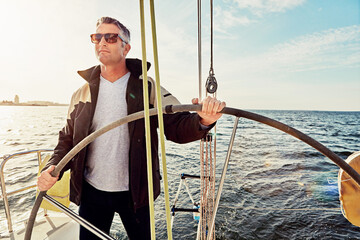 Sailing, yacht and man with wheel for navigation, adventure and holiday hobby with summer ocean and...