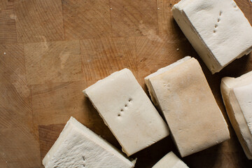 Overhead view of hardtack bread on a wood chopping board, top view of nigerian hardtack also known as kpo kpo madiga