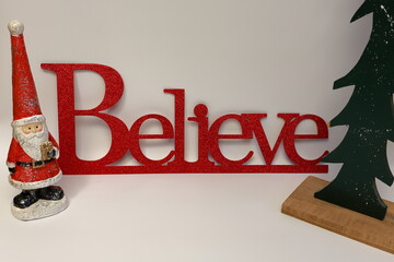 The word Believe next to a carved Christmas tree with a clean seamless white background