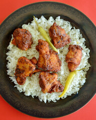 Tikka masala chicken pieces on a bed of long grain white rice.