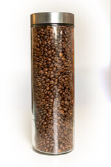 Glass container filled with roasted coffee beans showcases the rich aroma of fresh coffee in modern kitchen decor
