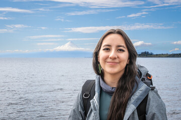 Puerto Varas, Los Lagos, Chile. Young woman traveler - tourist next to the snow-capped volcano...