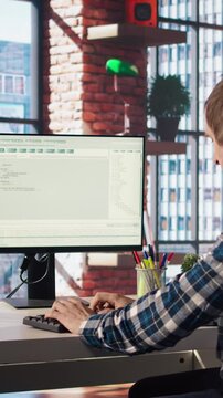 Man in home office looks at green screen tablet and computer, typing and executing programming code. Coding application used by IT developer writing and testing code using chroma key device, camera A