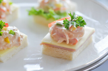 canape or toast with ham , cheese , crab stick and tuna