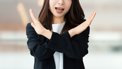 手でバツのポーズをする女性・ビジネスウーマン