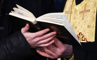 The religious book Trebnik is held in hands