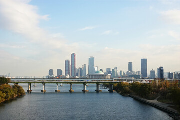 Fototapeta premium A skyline of Yeouido, Seoul, Korea with modern skyscrapers and a bridge over a river.