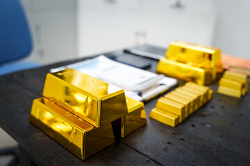 Obraz premium Gold bars and gold coins are placed next to a financial report on a table, symbolizing investment analysis and financial growth, creating a scene of wealth and economic strategy.